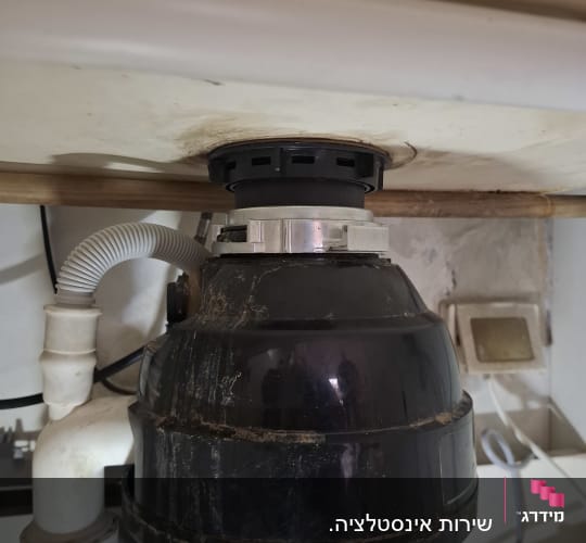 מתקן אינסטלציה מתחת לכיור עם צינורות וחיבורים